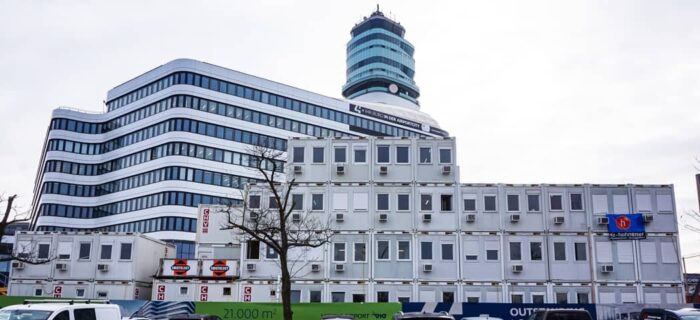 Vierstöckiges modulares Baubüro Office Park 4 Flughafen Wien, bestehend aus 87 Bürocontainer mit einem fix verglasten Doppelcontainer als Besprechungszimmer im zweiten Stock. Baujahr 2019/2020