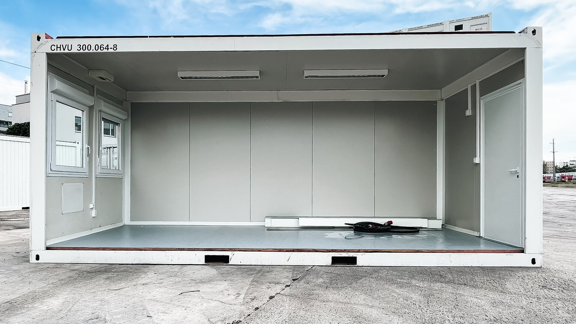 Innenraum: offener Grundriss mit Teppichboden, Rollladen-Fenstern und vorbereitetem Heizer