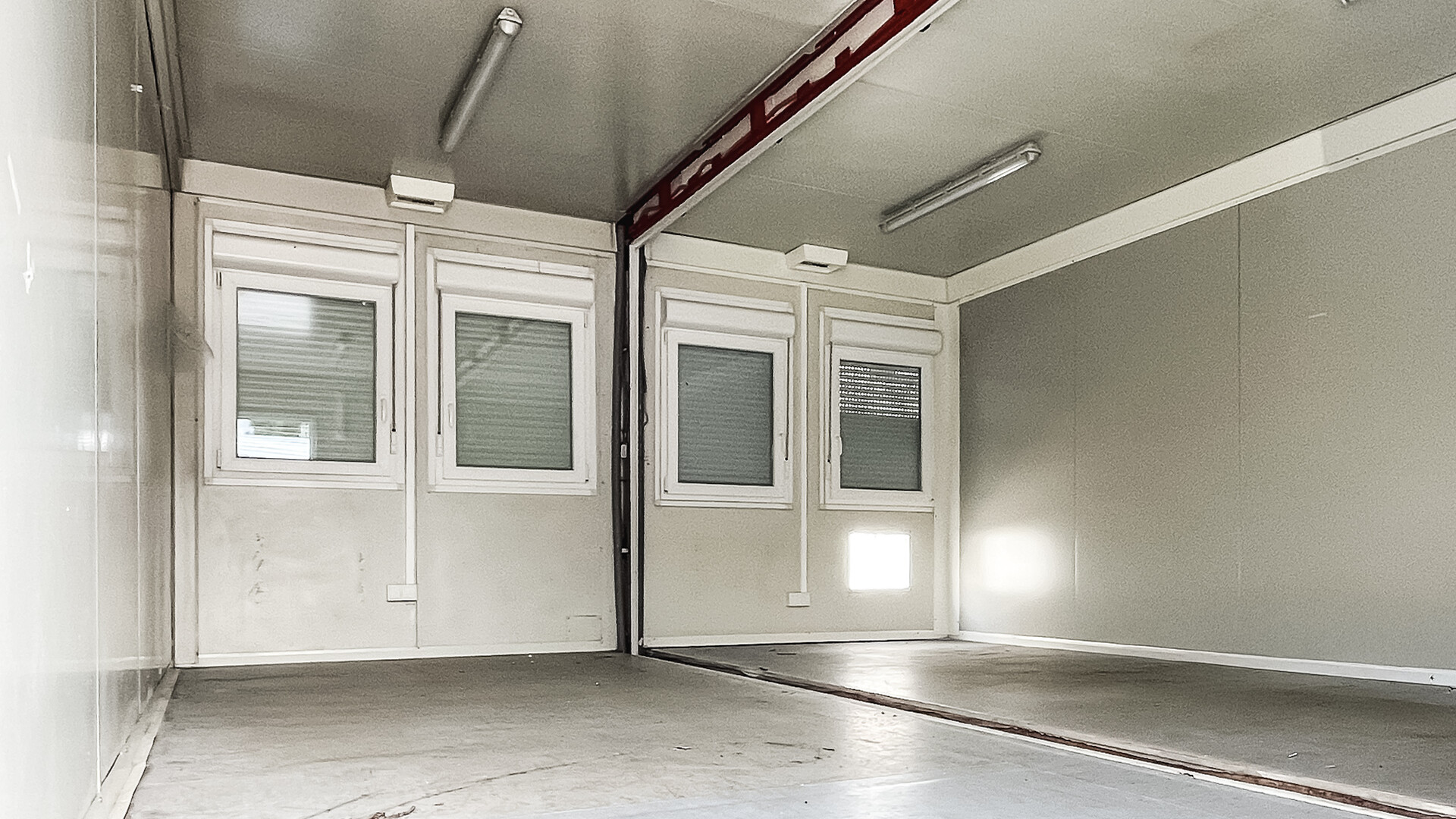 Innenraum gebrauchte Container Doppelanlage 30 m², PVC‑Boden und Beleuchtung