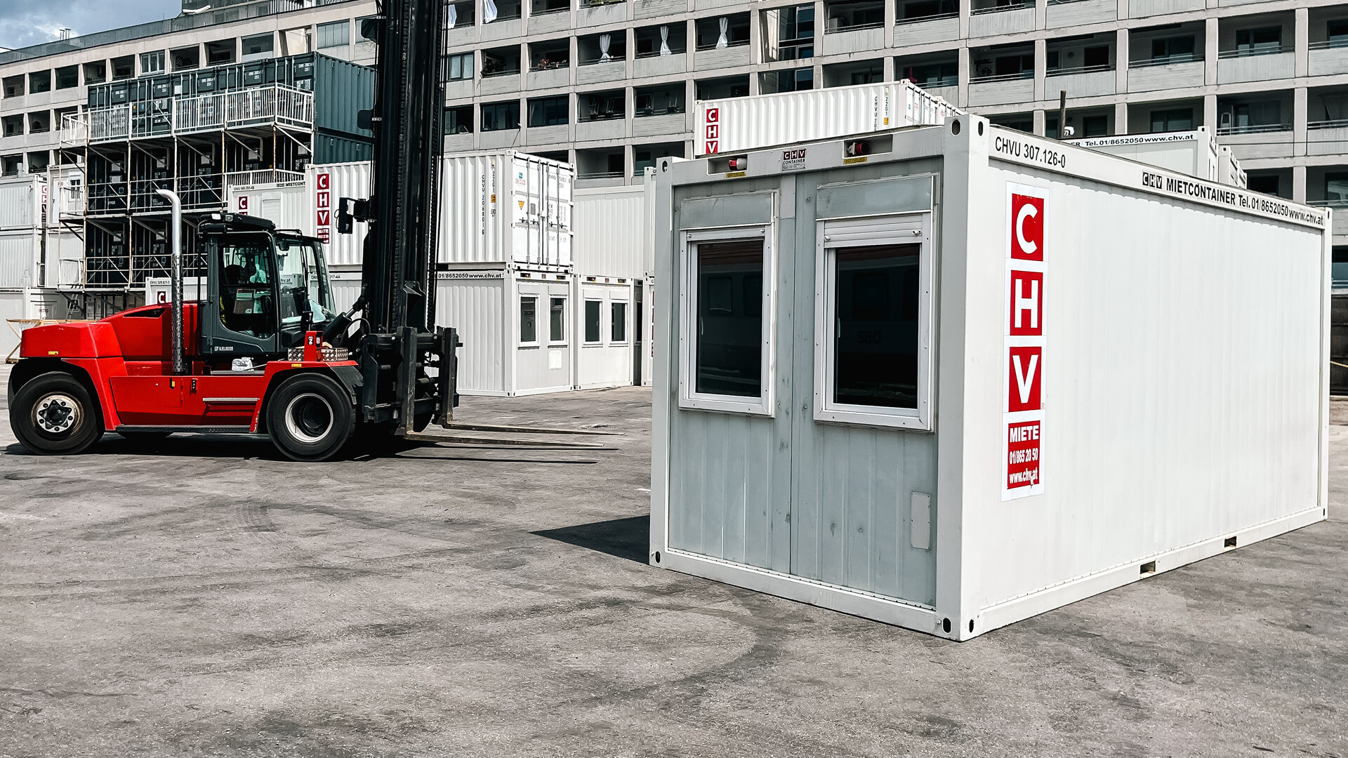 Kran-LKW hebt Container­modul bei Anlieferung